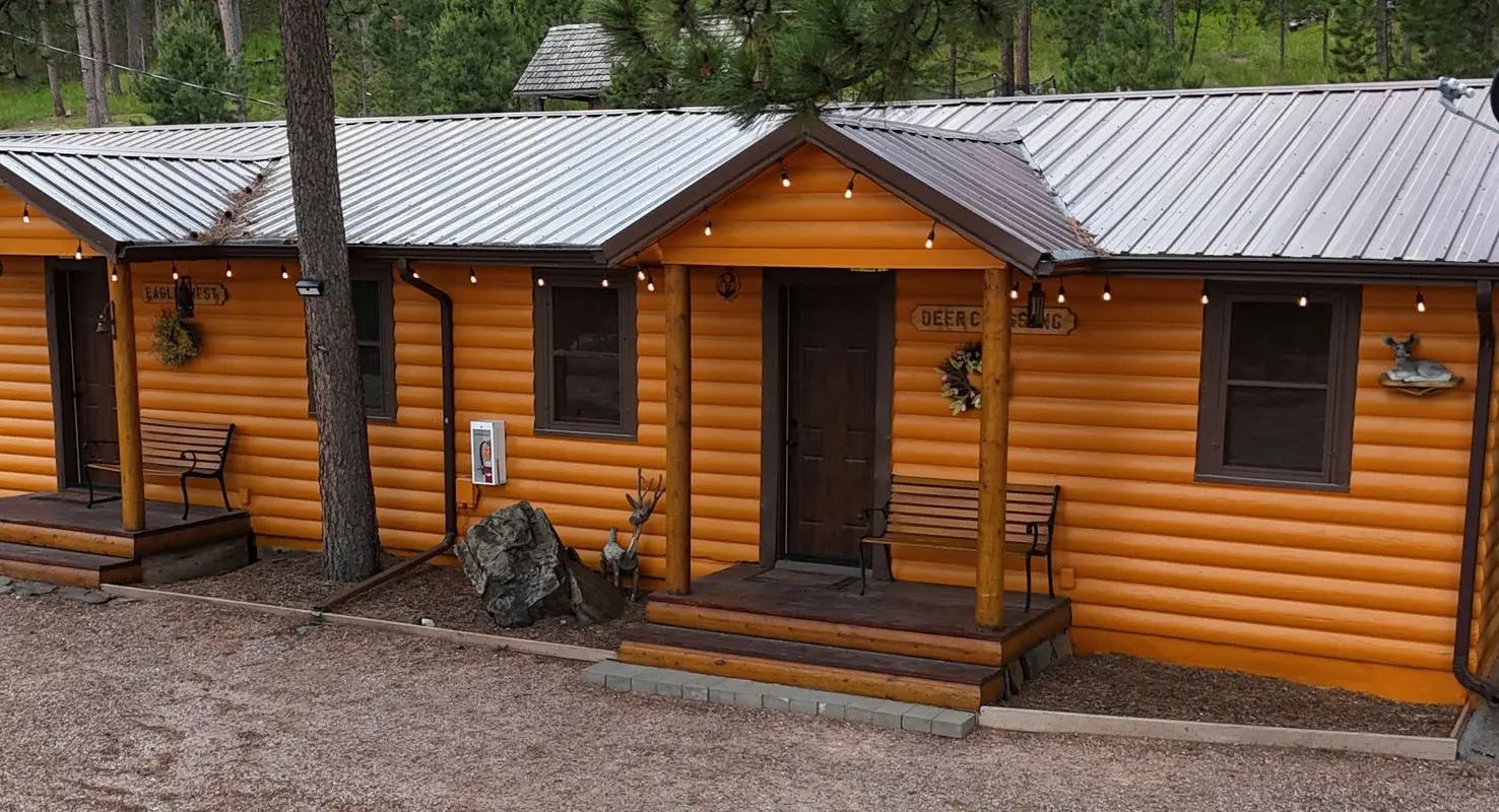 A cabin with a porch and bench outside