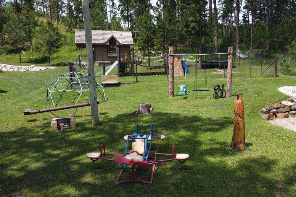 A park with swings, slides and a slide.