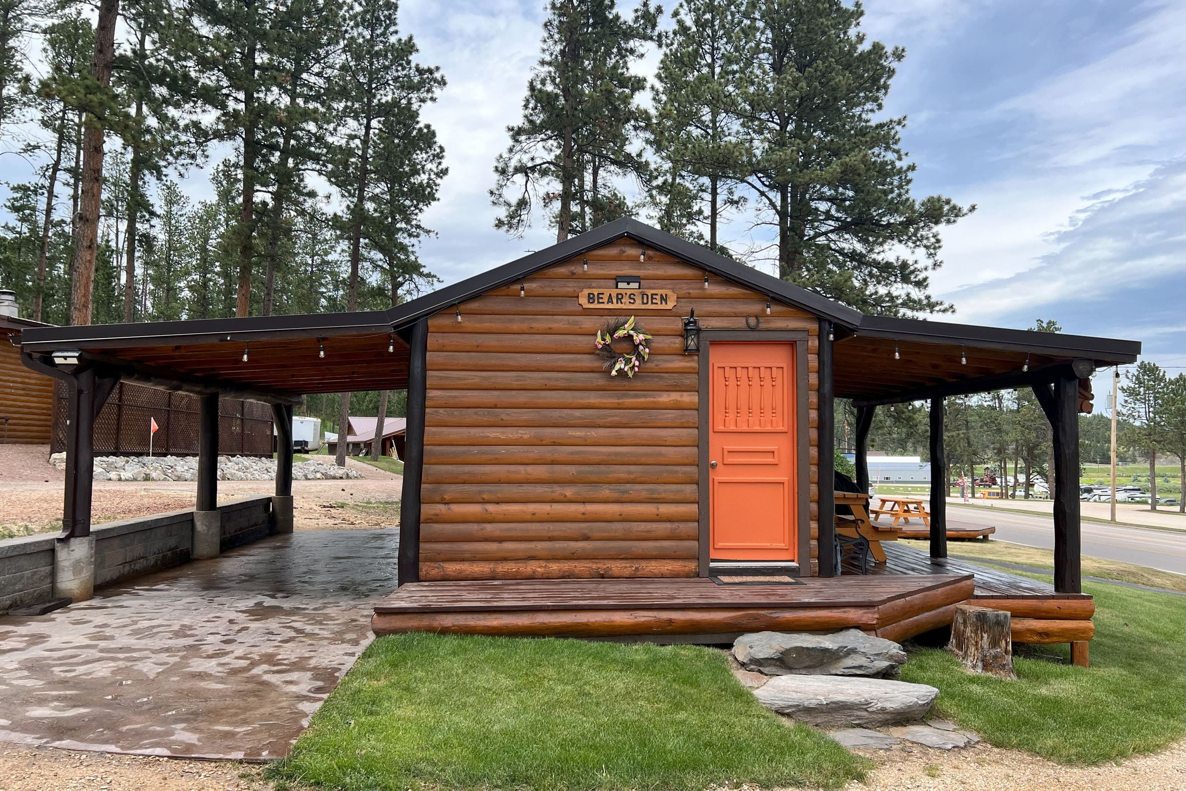 A cabin with a orange door and some trees