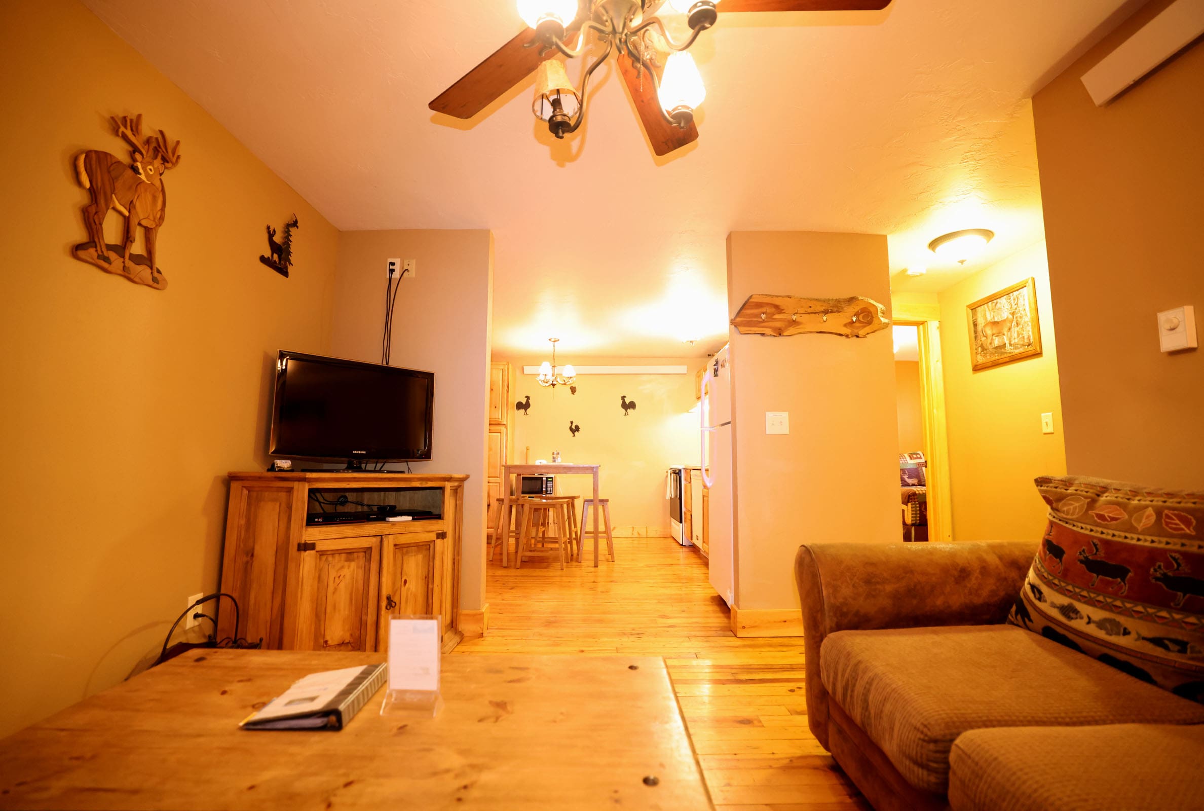 A living room with hard wood floors and a ceiling fan.