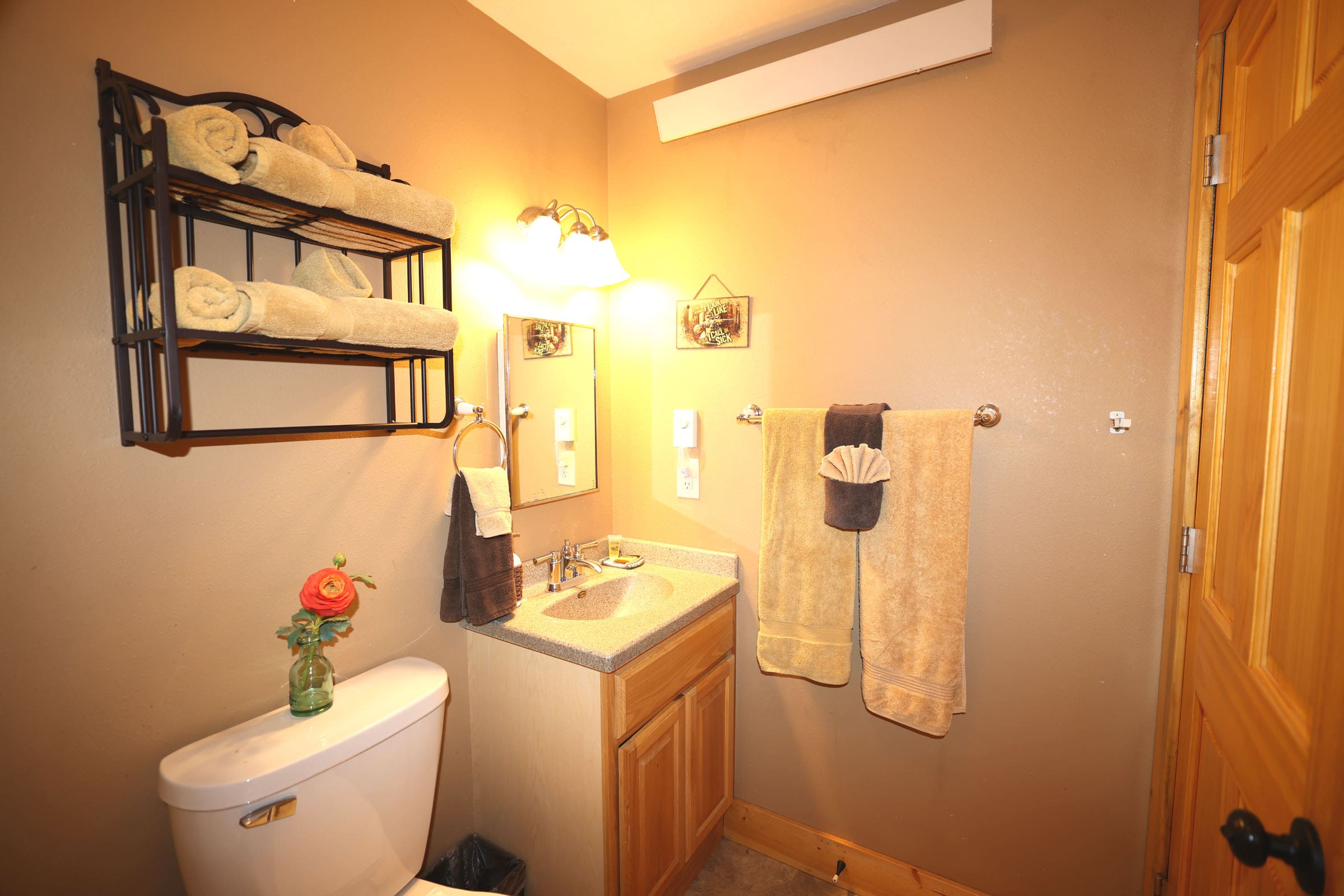 A bathroom with a toilet, sink and mirror.