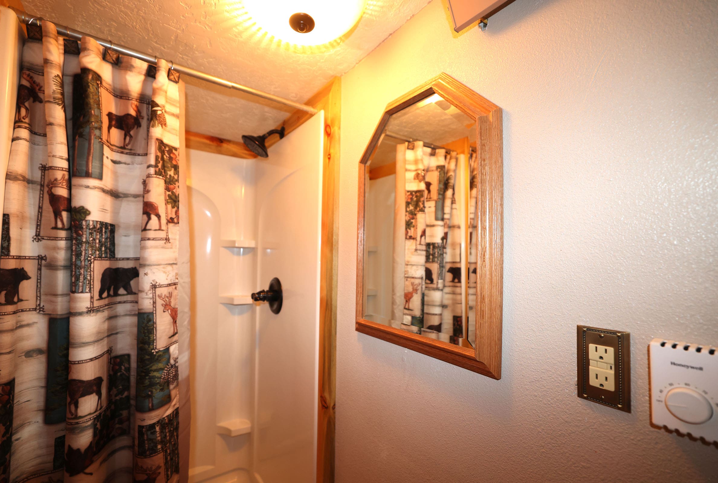 A bathroom with a shower and mirror in it