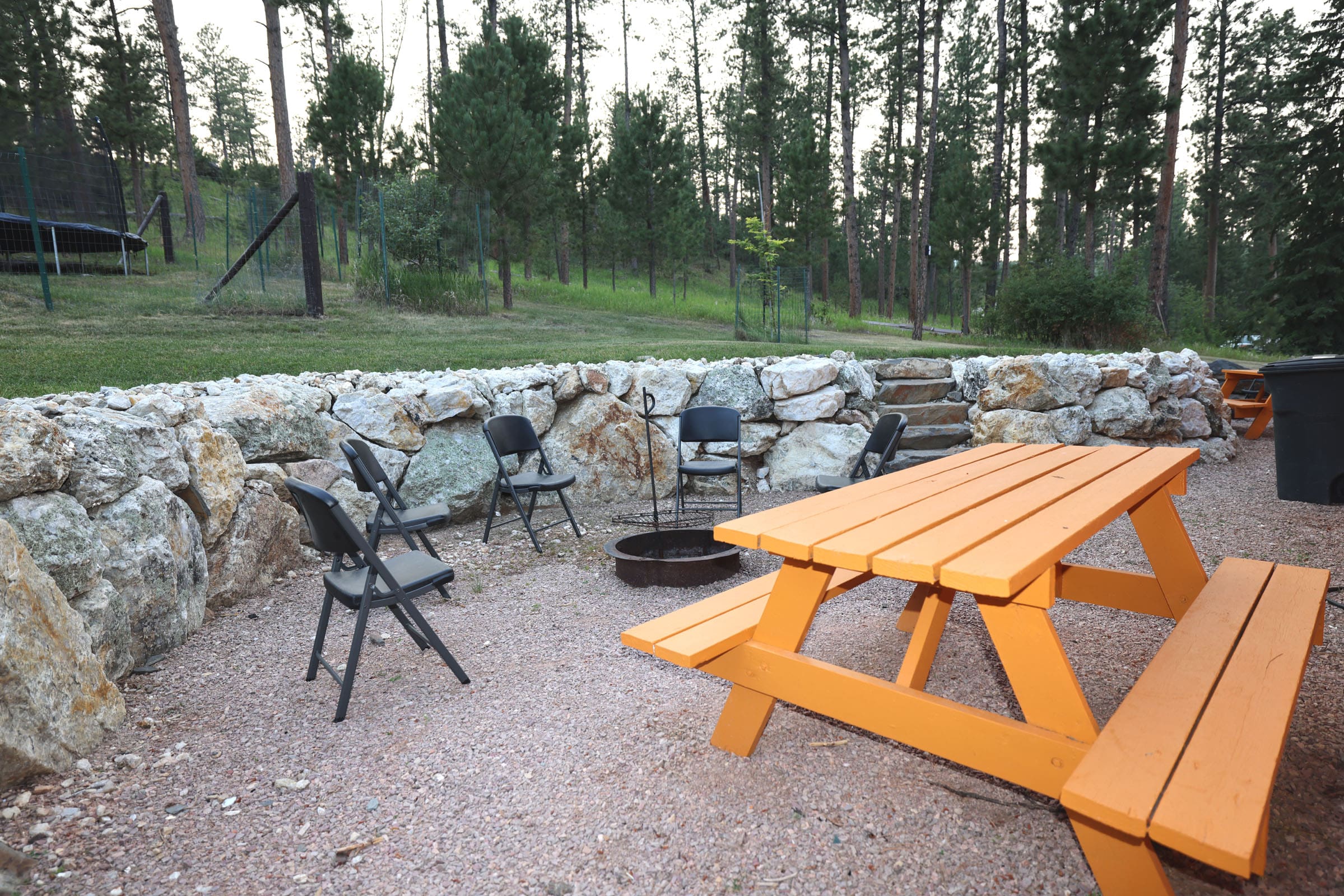 A picnic table and chairs in the gravel.