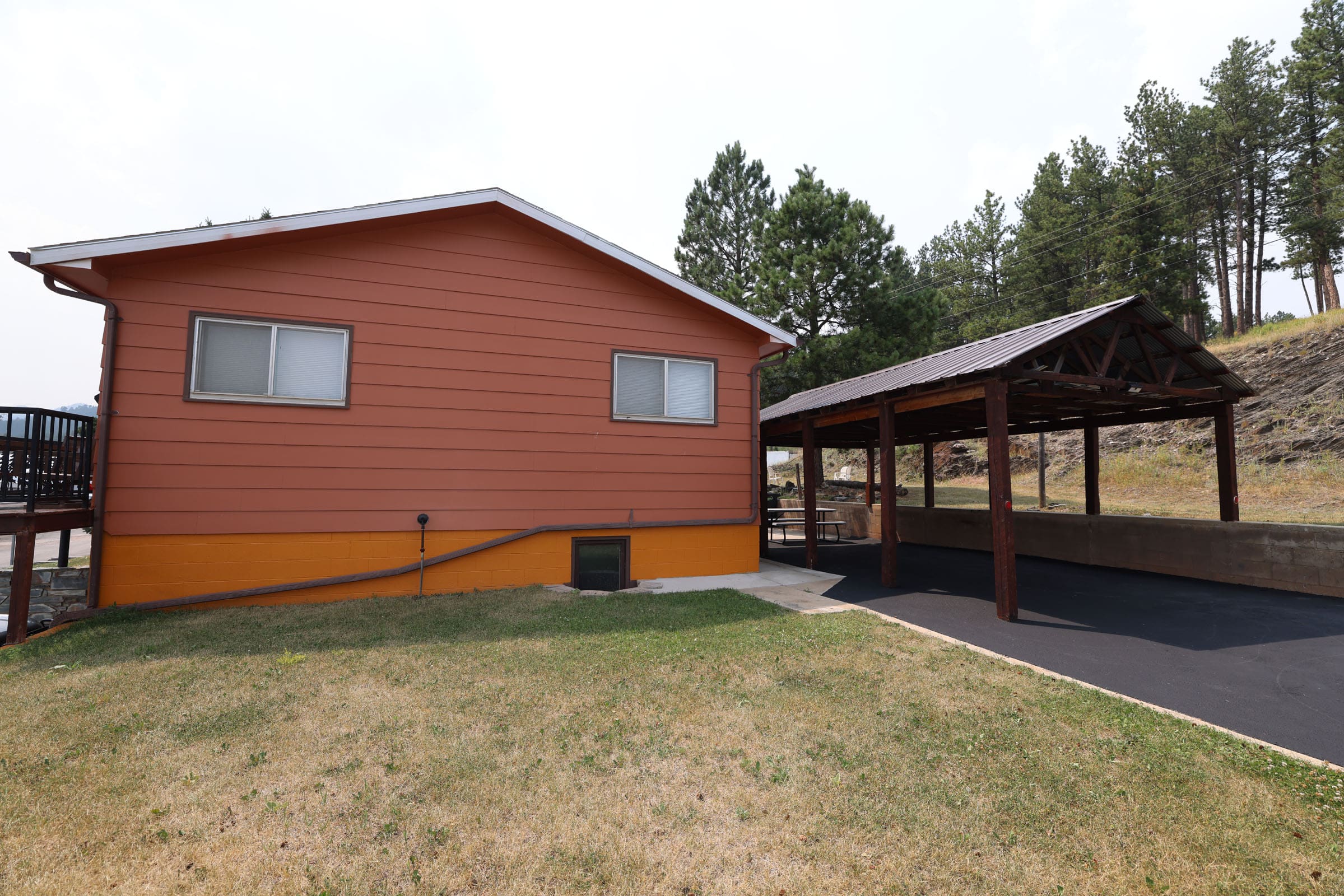 A large red house with a covered area in the back.