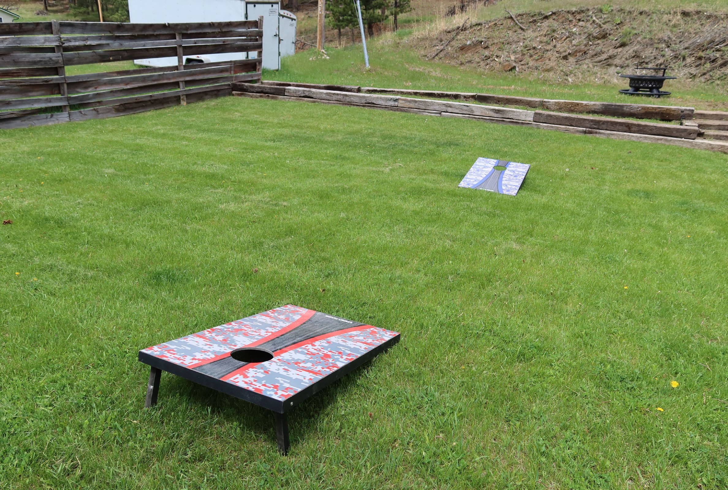 A game of corn hole in the grass.