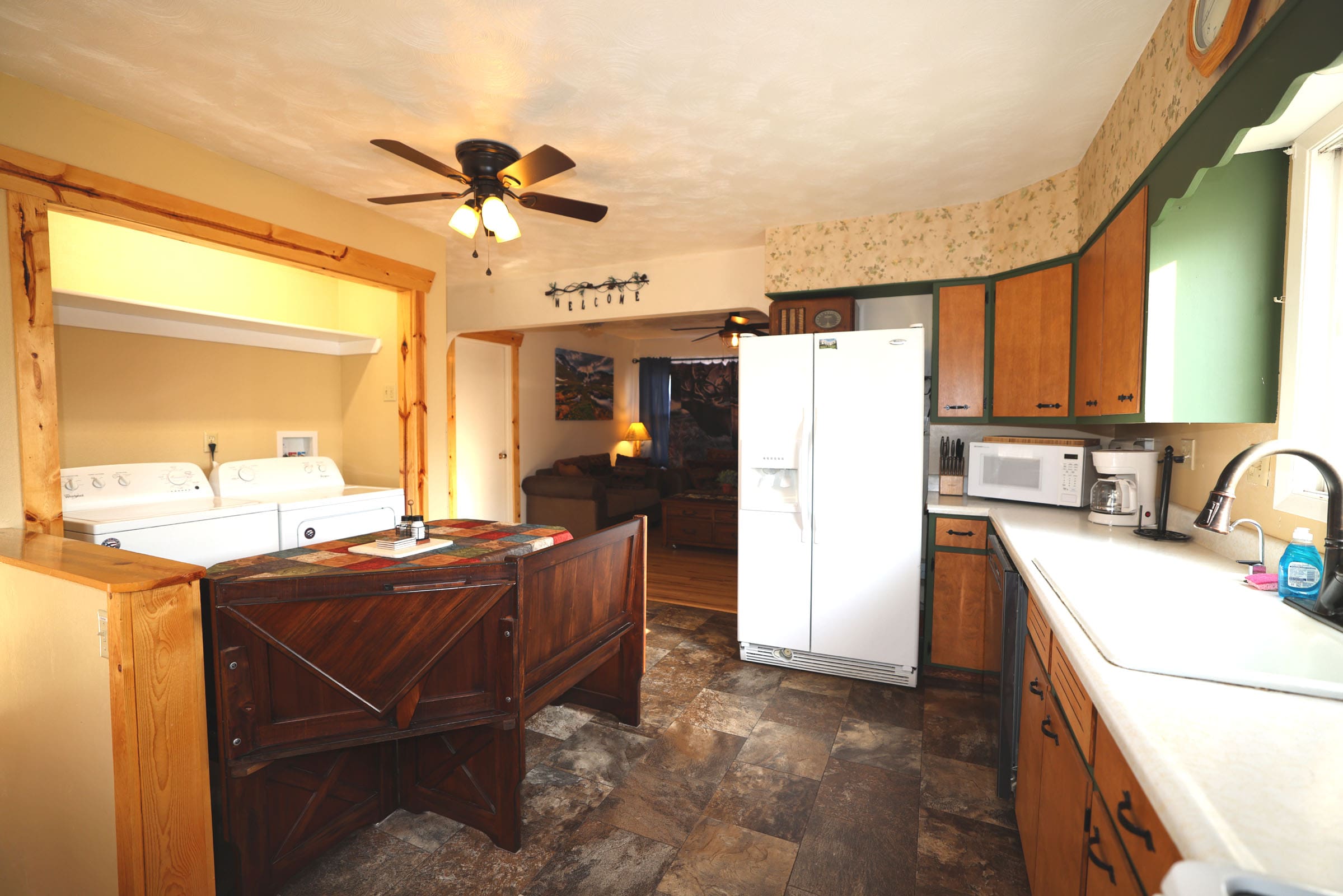 A kitchen with a sink, refrigerator and microwave.