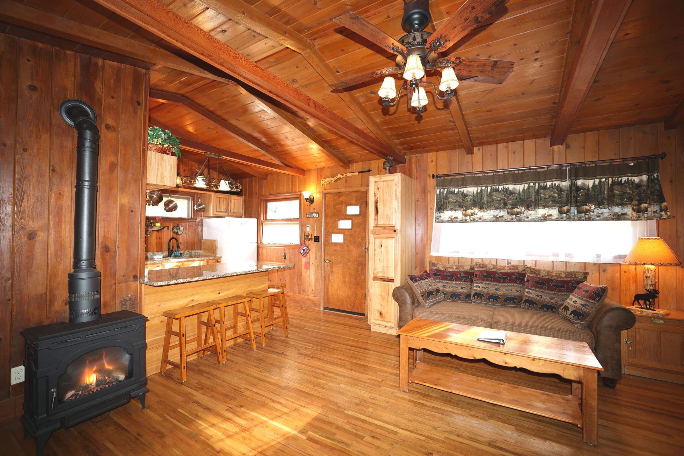 A living room with wood floors and wooden walls.