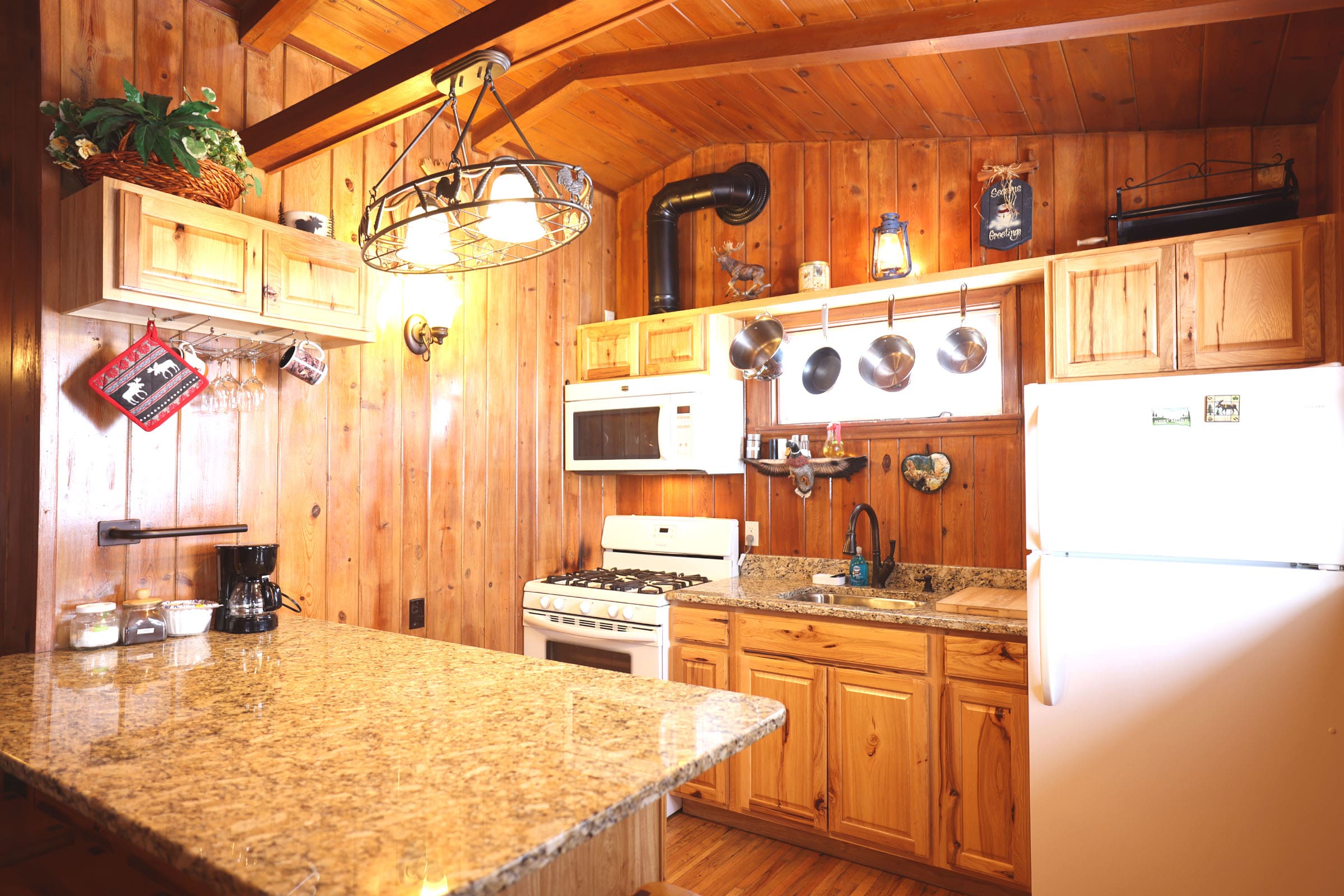 A kitchen with wood paneling and white appliances.