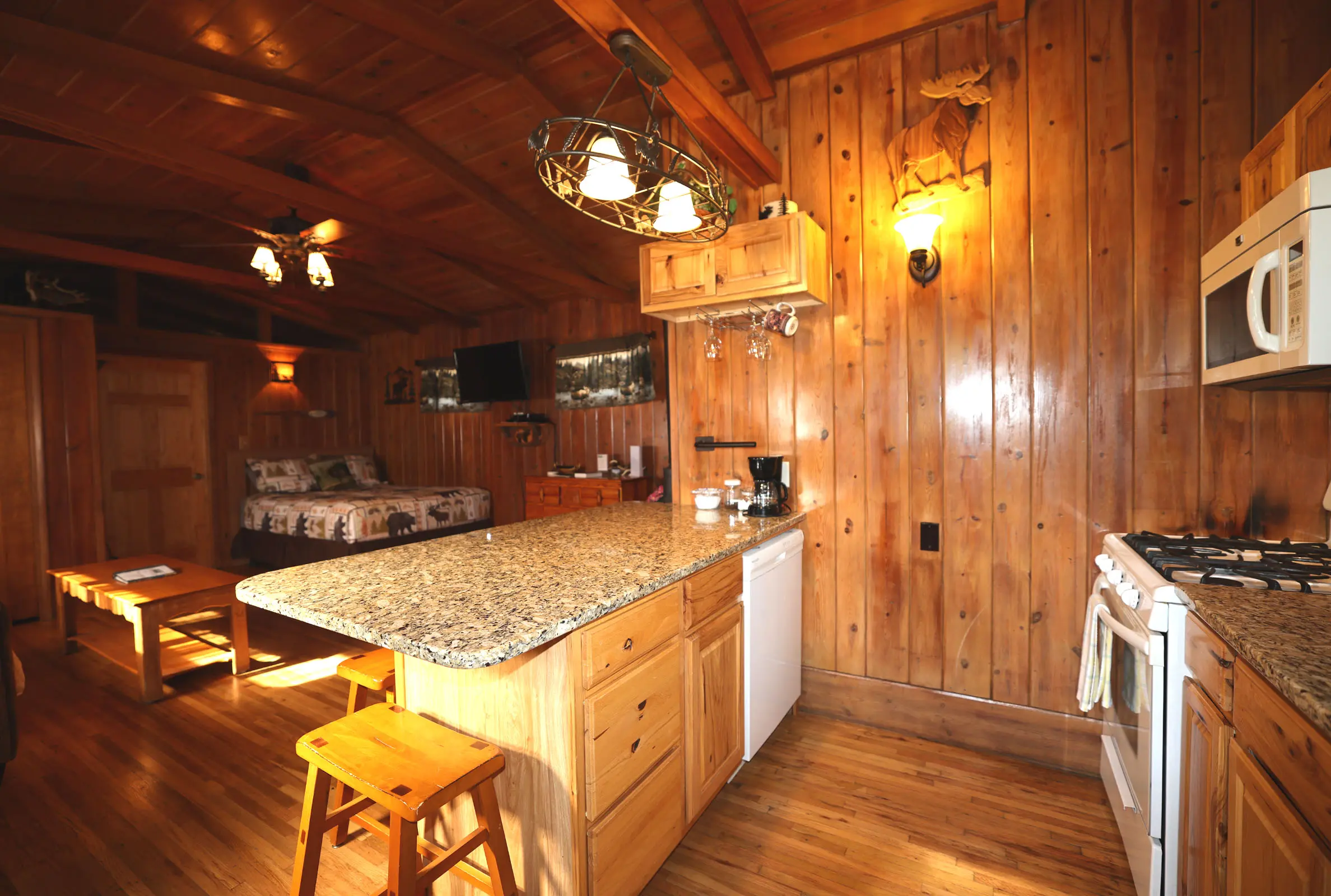 A kitchen with wood paneling and wooden floors.