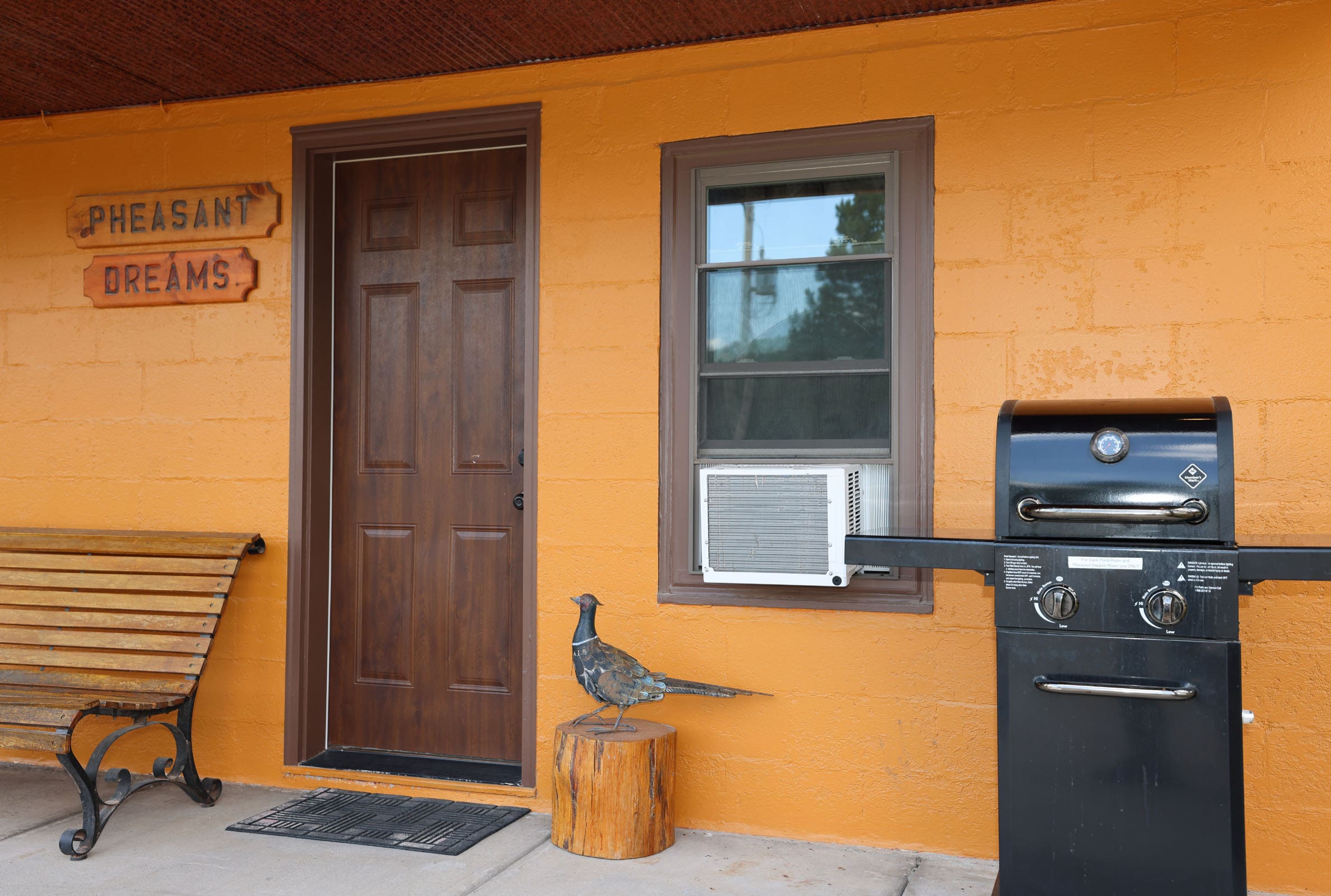 A bird sitting on the door of an orange house.