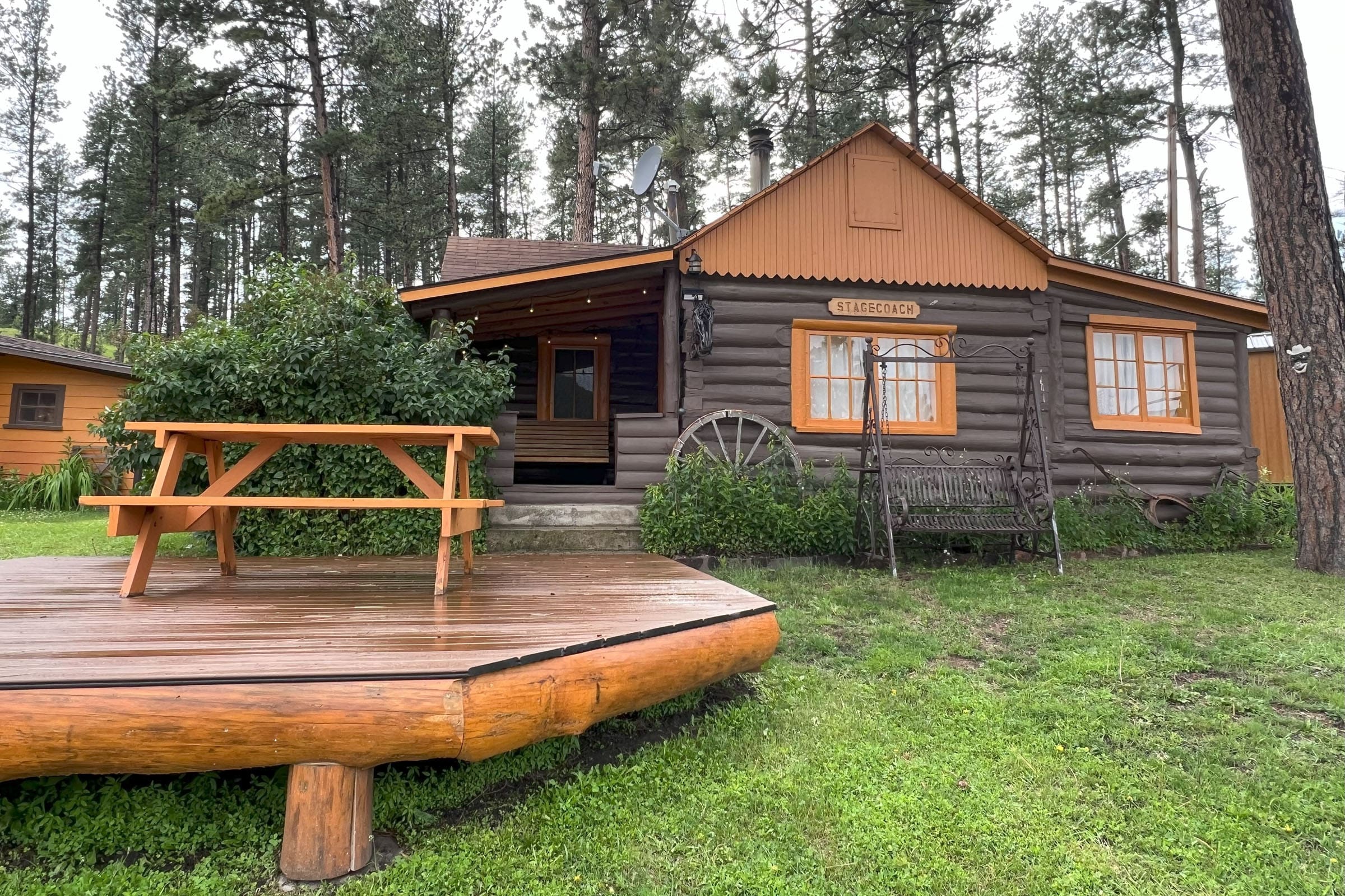 A cabin with a picnic table in front of it.