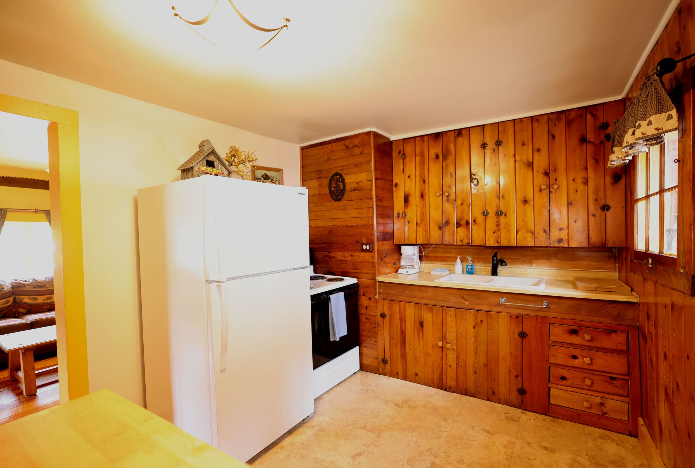 A kitchen with wood paneling and white appliances.