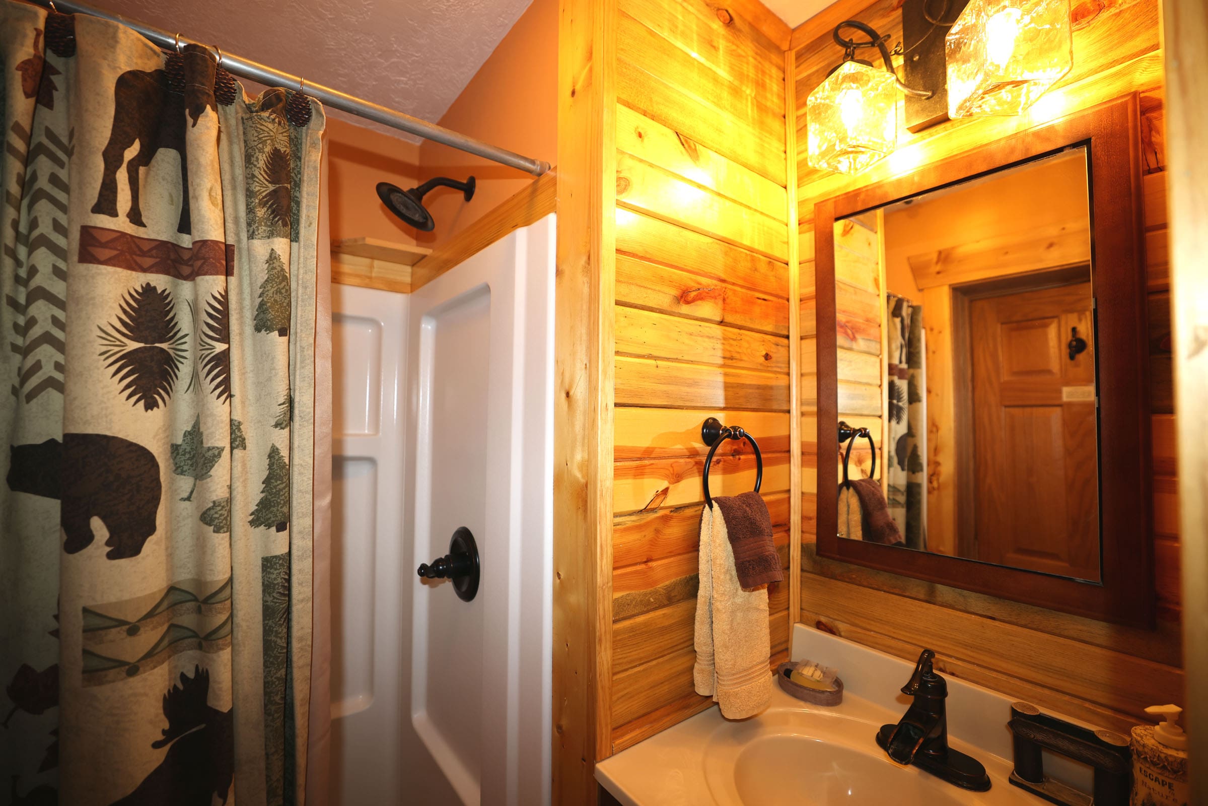 A bathroom with wood paneling and a shower.