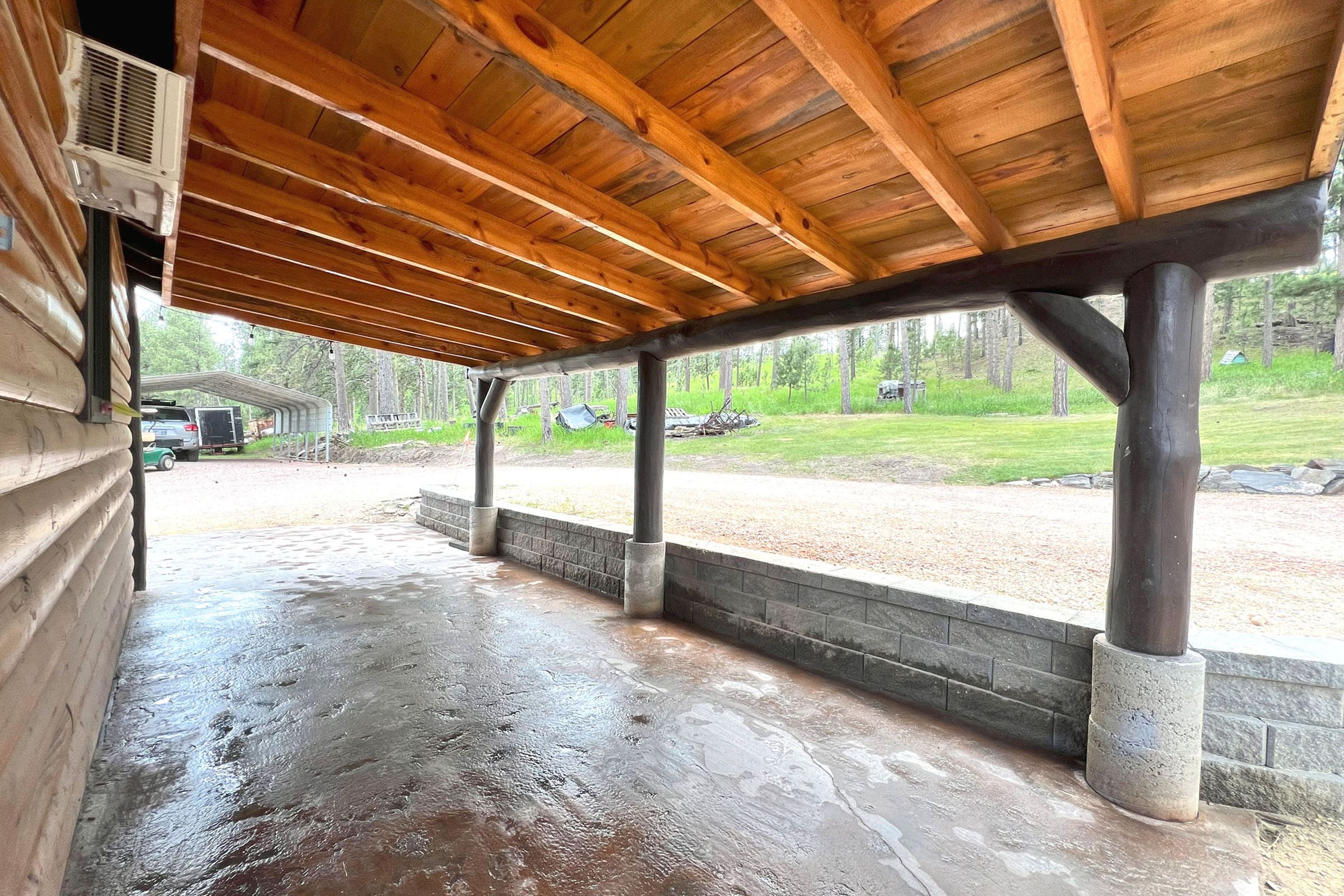 A wooden structure with concrete pillars and wood beams.