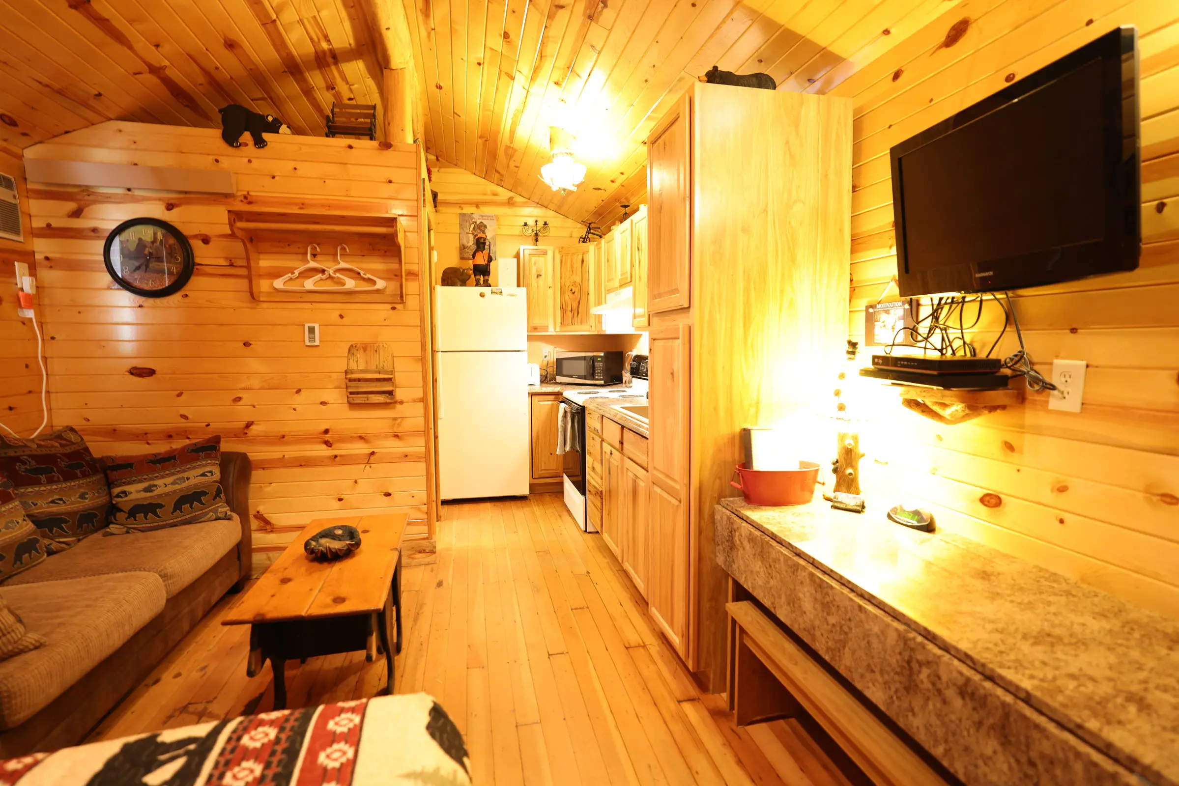 A kitchen with a couch and refrigerator in it