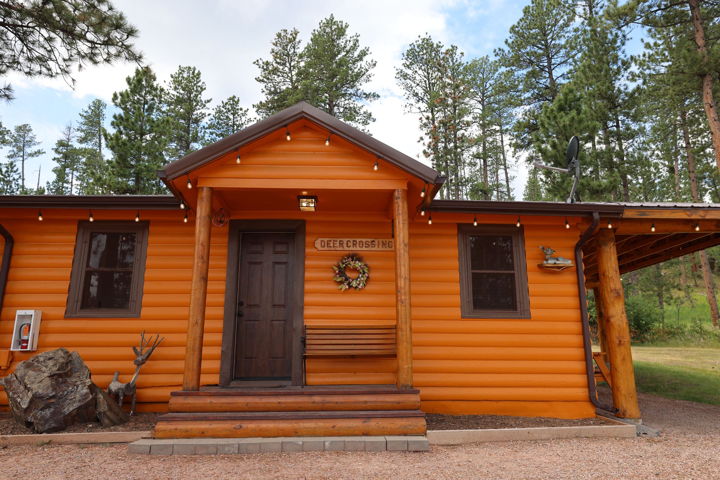 A cabin with a porch and steps leading to the front door.