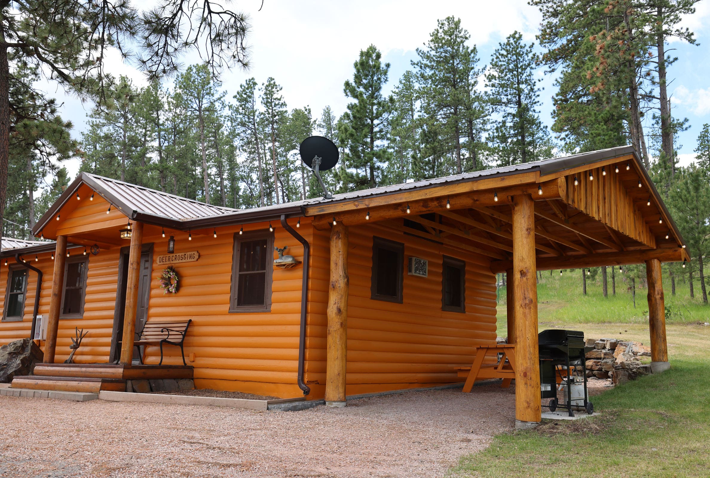 A cabin with a porch and picnic table in the back.