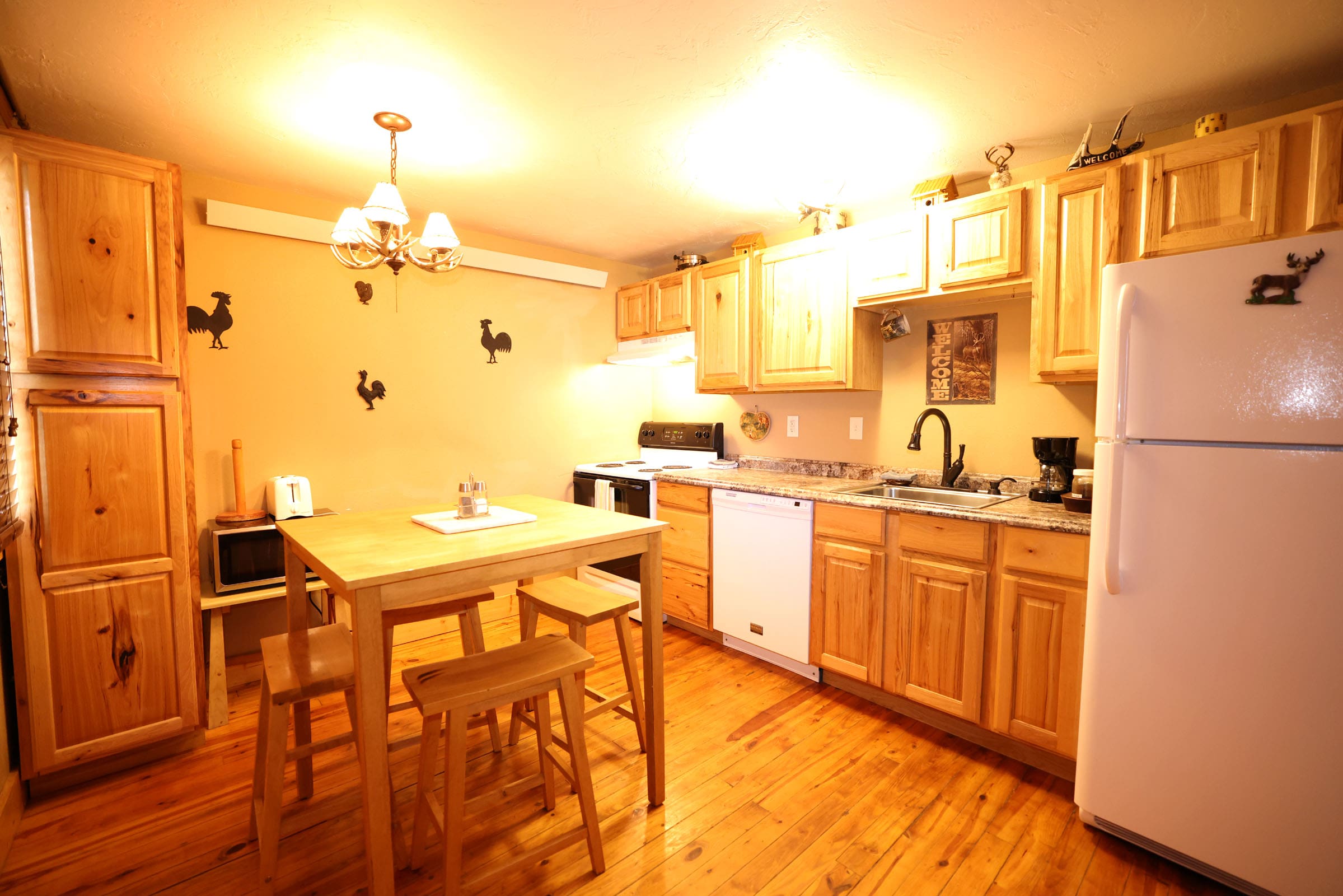 A kitchen with wooden cabinets and wood floors.