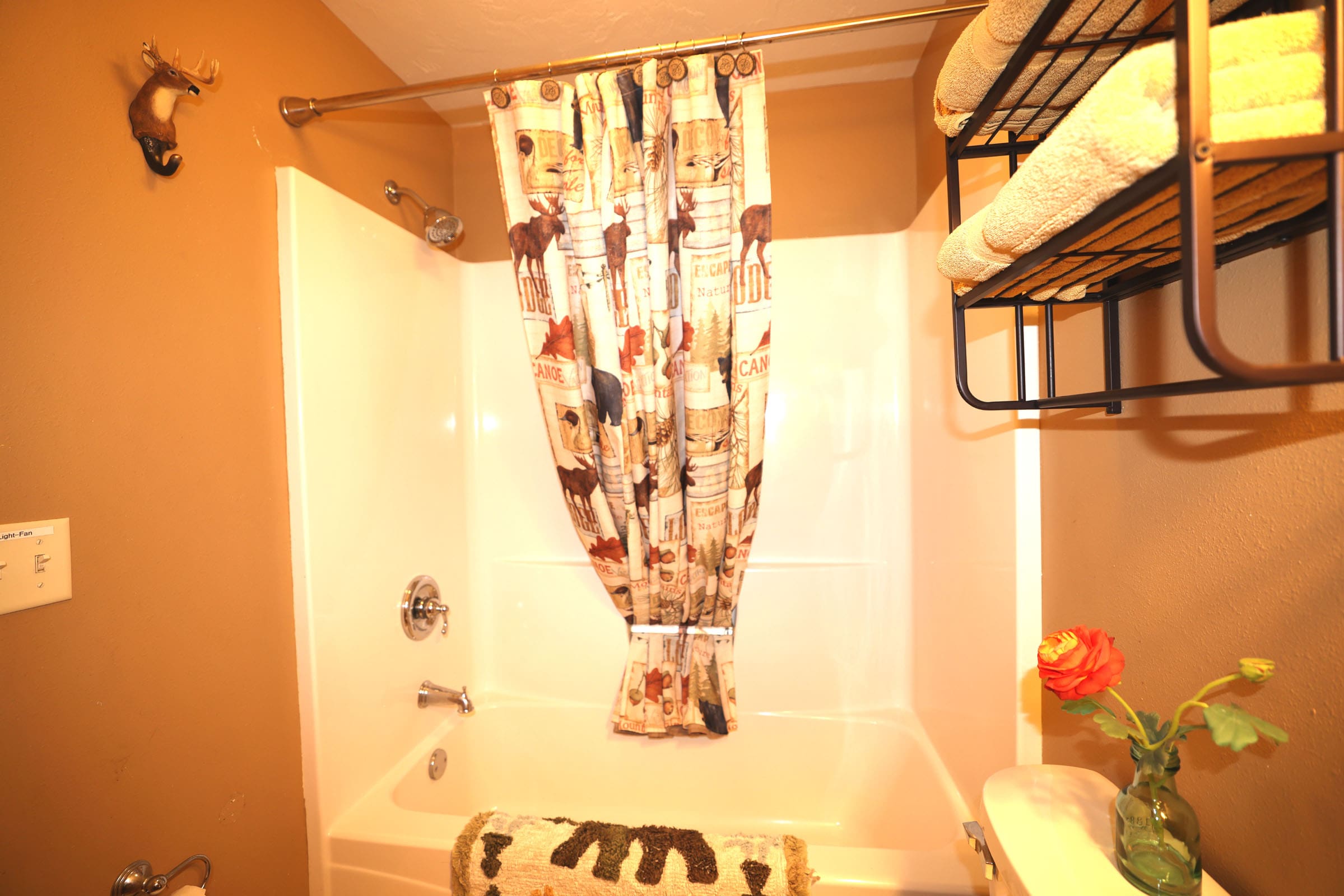 A bathroom with a tub, shower curtain and towel rack.