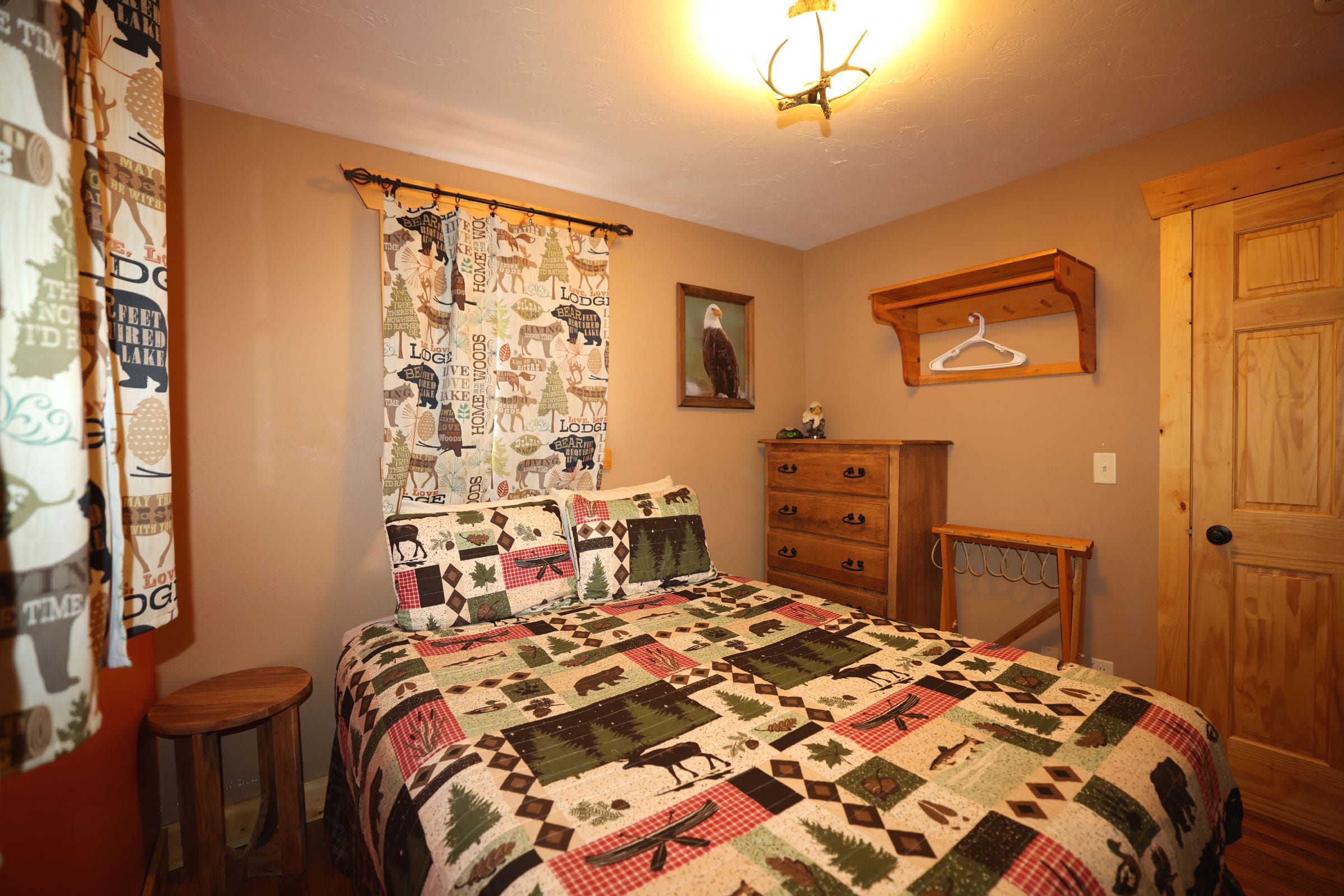 A bedroom with a bed, dresser and window.