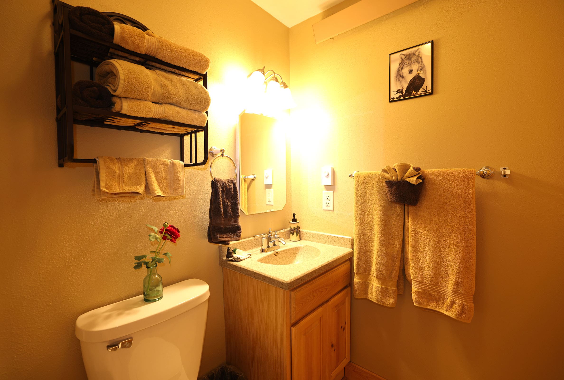 A bathroom with a sink, toilet and mirror.