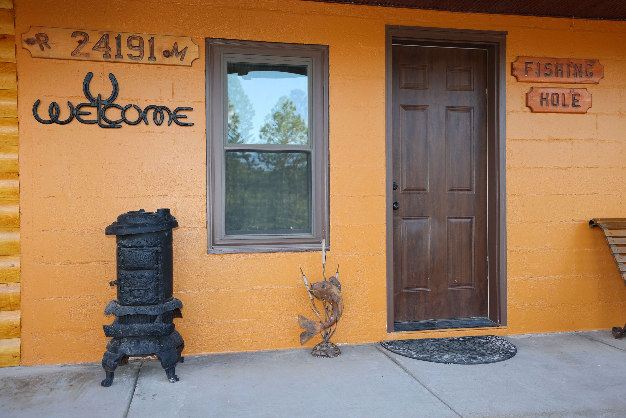 A yellow house with an old fashioned stove and door.