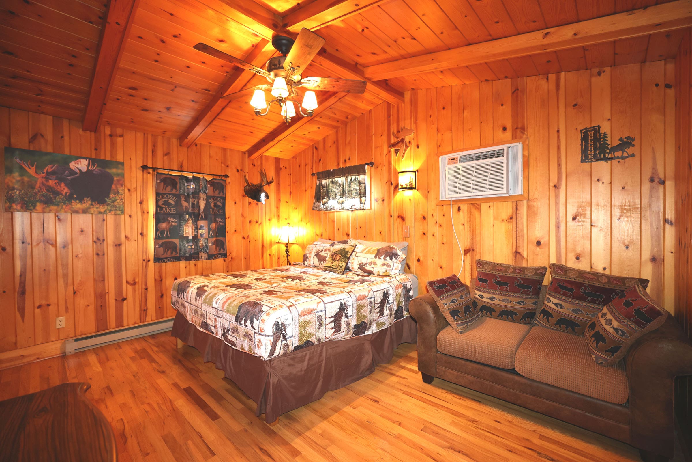 A bedroom with wood paneled walls and ceiling.