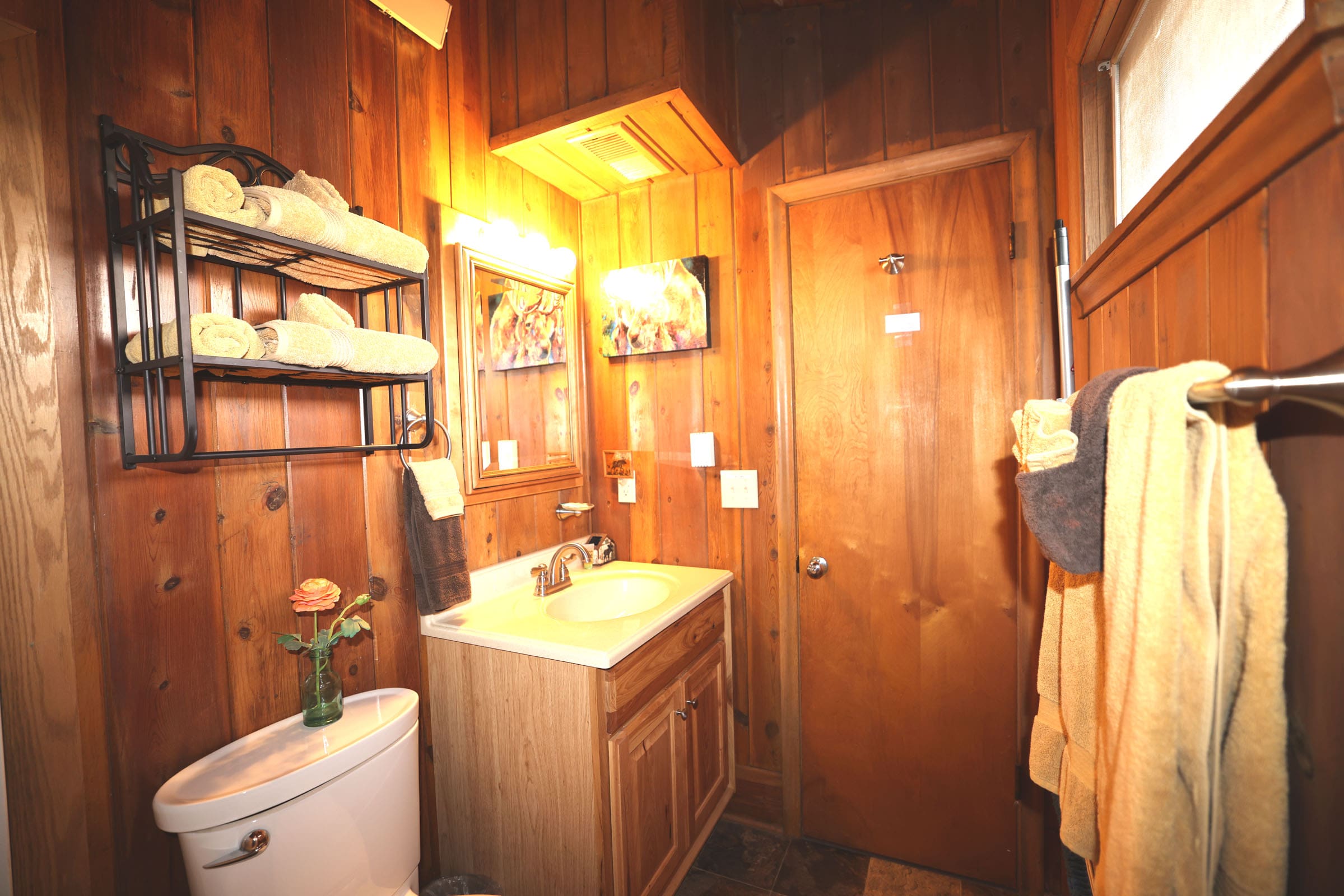 A bathroom with wood paneling and a sink.