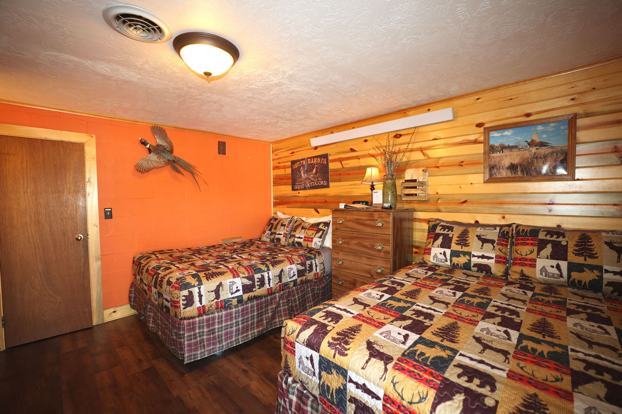 A bedroom with two beds and a dresser